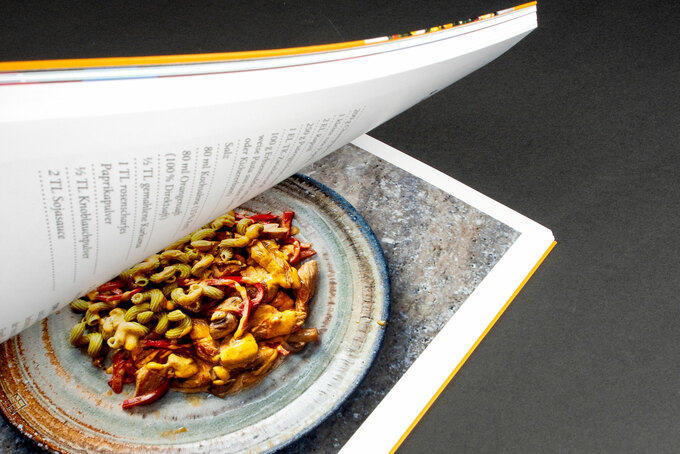 aufgeschlagenes Kochbuch mit Schutzumschlag